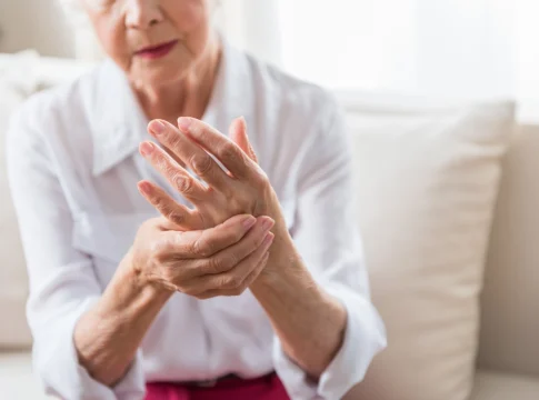 A woman who has arthritis holds her hand