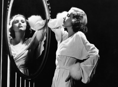 Glamorous woman looking in mirror