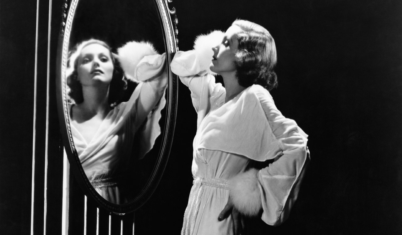 Glamorous woman looking in mirror Glamorous woman looking in mirror