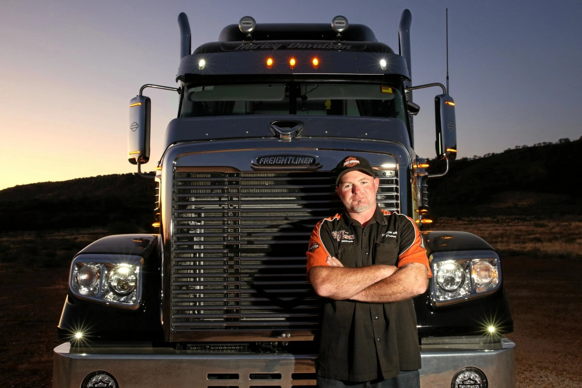The driver is standing in front of his truck The driver is standing in front of his truck