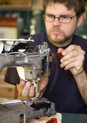 A man fixes a sewing machine